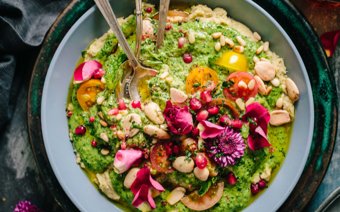 top view of a plate of salad, mixed with guacamole and flower pedals